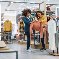 two women inspect an article of clothing