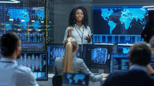 a black woman gives a speech to a group of people in a data center
